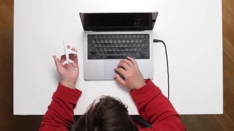 Top view Man booking flight tickets online using laptop and holding toy airplane Stock Footage 311202493