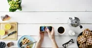 Top View Man Browsing Vacation Photographs Using Smartphone At Breakfast Belgian Stock Footage