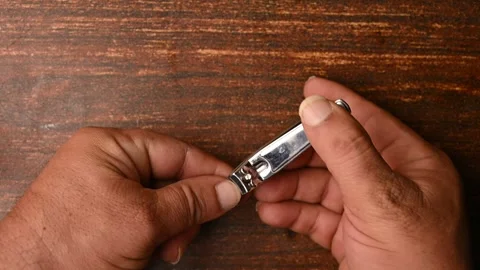 Top View of a Man Cutting Fingernails on Wooden Table – Personal Grooming Stock Footage 329340069