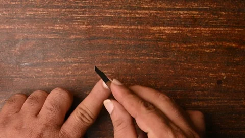 Top View of a Man Cutting Fingernails on Wooden Table Stock Footage 329347142