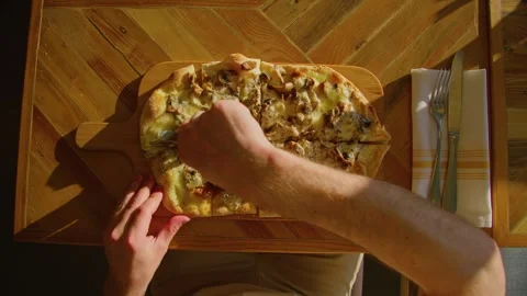 Top view of a man cutting pizza with mushrooms and cheese with roller knife, POV Stockbeeldmateriaal 243749412