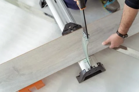 Top view of a man cutting a sheet of wood with a guillotine for the installation Stock Photos