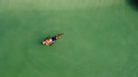 Top view of a man floating relaxed in the sea on vacation Stock Footage 170598428