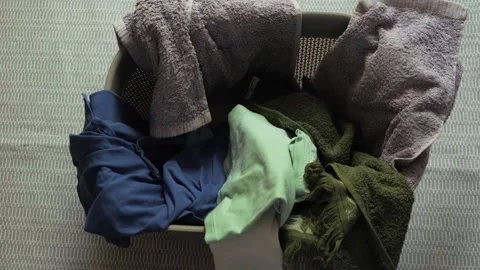 Top view. Man folds clean things and takes away. 動画素材 197568341