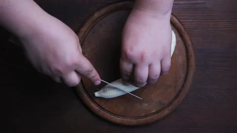 Top view. Man hand cut or chopping peeled banana on a cutting board. Sliced big Stock Footage 133594515