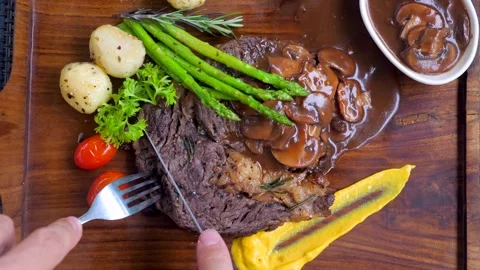 Top view of man hand cutting by knife ribeye beef steak Video stock 241778389