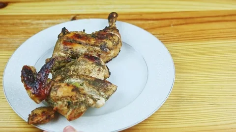 Top view on man by hand moves white plate with half of roasted in herbs chicken Stock Footage 143555997