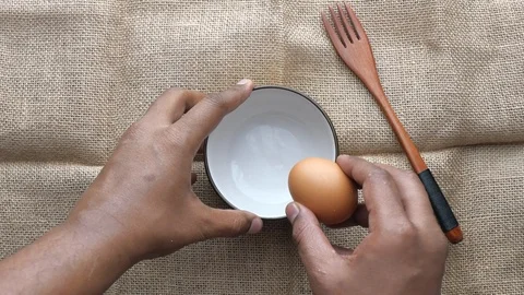 Top view of man hand processing egg in a bow Stock Footage 124720258