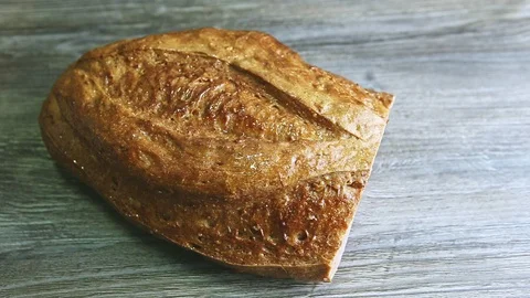Top view man hand slice half of oblong wheaten bread by knife 스톡 동영상 120476125