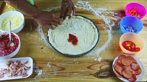 Top view on man by hands makes borders of pizza dough on still round baking dish Stock Footage 139428586
