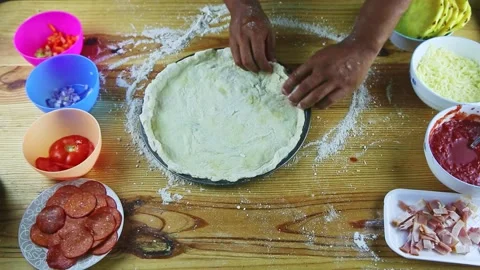 Top view on man by hands makes borders of round pizza dough on still baking dish Stock Footage 139991404