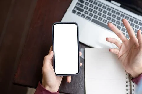 Top view of a man holding white screen phone with questioning hand over not.. Stock Photos