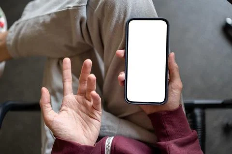 Top view of a man holding white screen phone with a questioning confused ha.. Stock Photos