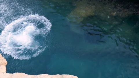 Top view of a man jumping from cliff in sea water Stock Footage 108387726