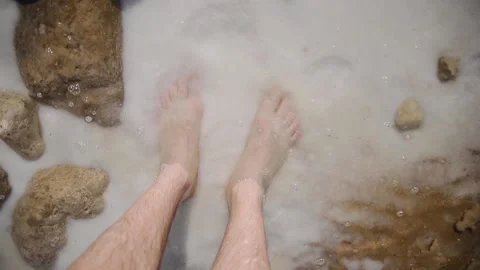 Top view of man legs that washing by sea water with salt. Dead Sea coastline Stock Footage 181646746