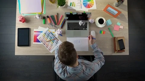Top view on man looking for startup ideas, writing on paper and crumpling it Stock Footage