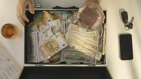 Top view of man opens suitcase full of euro dollar currency cash money banknotes Stock Photos