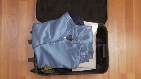 Top view of man packing clothes in suitcase quickly Stock Footage 74087384