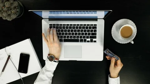 Top view.A man paying for online shopping using laptop and credit card. Stock Footage 74212232