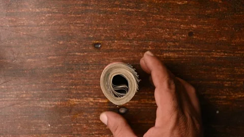 Top View of a Man Placing 500 Rupee Round Bundle on Wooden Table Stock Footage 329339662