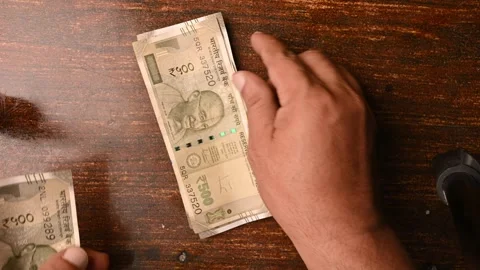 Top View of Man Placing 500 Rupee Notes One by One on Wooden Table 動画素材 329343669