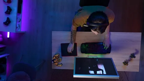 Top view of man playing game on computer online, won the mission looking up Stock Footage 252660717