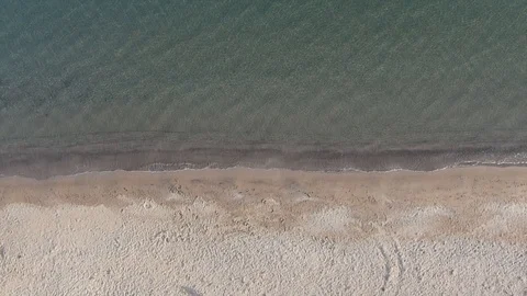 Top view of a man running along a sandy beach to the sea and diving into the Stock Footage 119834684