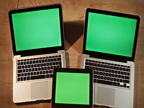 Top view man scrolling on digital tablet lying on two laptops Stock Footage 72412611