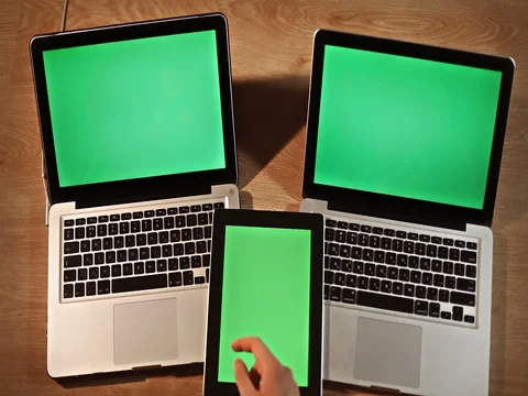 Top view man scrolling images,digital tablet lying on two laptops vertical Stock Footage 72412849