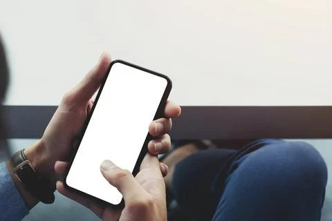 Top view man sitting and holding blank screen mock up mobile phone Stock Photos