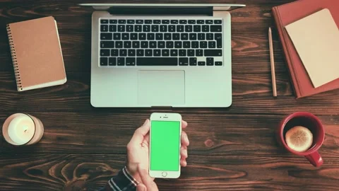 Top view of man sitting at cozy desk with organized order holding smartphone Stock Footage 143823772