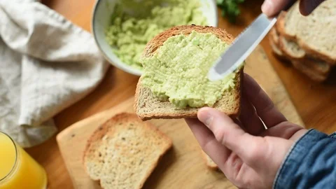 Top View Of Man Spread Avocado On Toast Bread Stock Footage 104788614