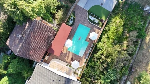Top View of a Man swimming alone in the luxury villa swimming pool. Aerial top Stock Footage 301785930