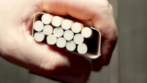 TOP VIEW: Man takes a cigarette from a pack Stock Footage 181785297