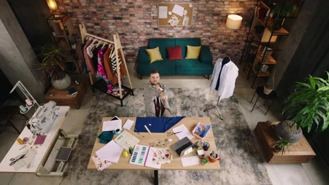 Top view. A man is in a very modern and hippie looking designer office, he is Stock Footage 194290915