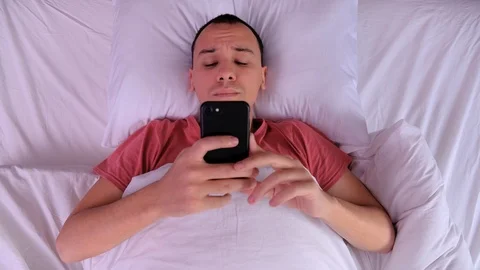 Top view man waking up and using her smartphone Stock Footage 123499990