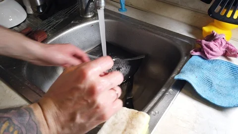 Top view of A man washes the dirty dishes in his kitchen Stock Footage 117929261