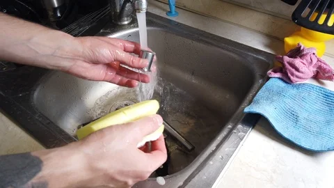 Top view of A man washes the dirty dishes in his kitchen Stock Footage 117931537