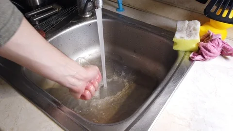Top view of A man washes the dirty dishes in his kitchen Stock Footage 117932704