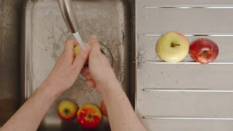 TOP VIEW: Man washes ripe apples under running water in sink. Close up 스톡 동영상 128284135