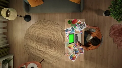Top view of a man working from home. Young designer is comparing the color Stock Footage 260056978