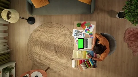 Top view of a man working from home. Young designer is comparing the textile Stock Footage 260057107