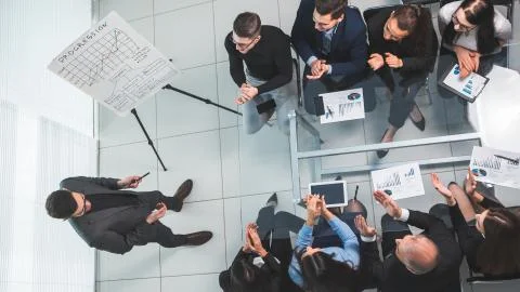 Top view. the Manager explains the new strategy to the working group. Stock Photos