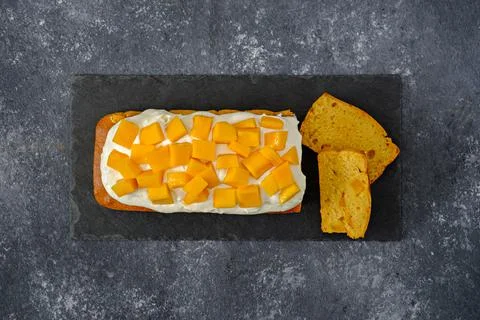 Top view mango cake on black stone, pound cake with whipped cream, mango dess Stock Photos