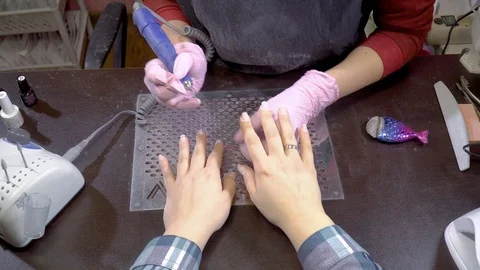 Top view manicurist remove cuticles using electric file nail drill Stock Footage 103476851