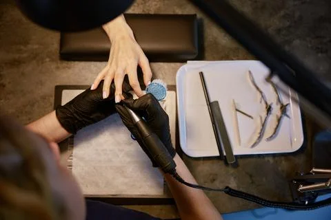 Top view on manicurist using multifunctional device for manicure Stock Photos