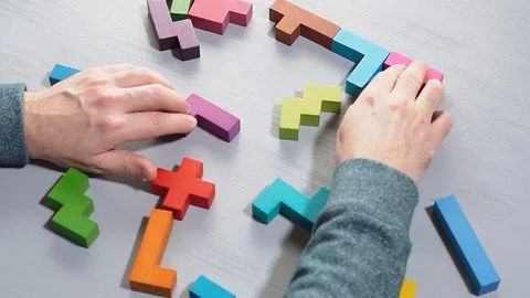Top view on man's hand connecting different geometric wooden blocks. Stock Footage 101160703
