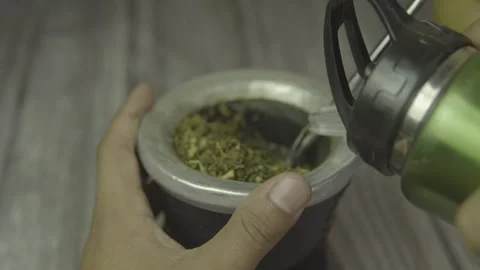 Top view of a man's hand placing water in a mate, traditional drink of argentina Stock Footage 272511053
