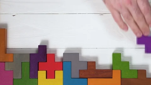 Top view on man's hand playing with colorful wooden blocks. Stock Footage 85081659