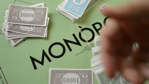 Top view man's hand put money on the monopoly board game. Stock Footage 213574045